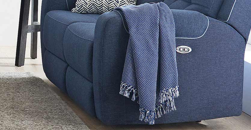 close up of a lounge suite sofa with a matching throw blanket over armrest